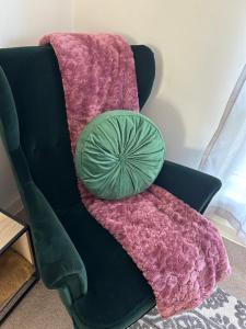 Salisbury的住宿－Sunshine Four，一张带粉色毯子的沙发上的绿色枕头
