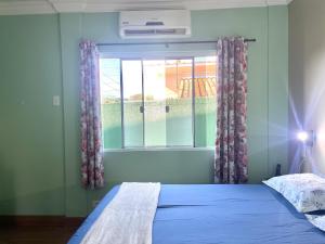 a bedroom with a bed and a window at CASA EM FOZ DO IGUAÇU DESTINO DO MUNDO in Foz do Iguaçu