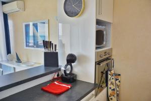 a kitchen with a counter with a clock on the wall at Lovely 51 m with harbour view in Saint-Cyprien
