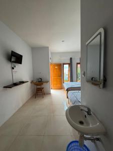 a bathroom with two beds and a sink and a mirror at Homestay Lereng Bromo in Bromo