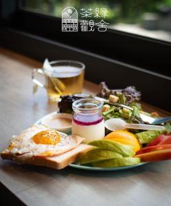 un plato de comida con un huevo en una mesa en 茶緣觀舍民宿 en Fanlu