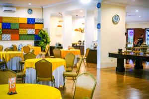 een eetkamer met gele tafels en stoelen bij Votel Manyar Resort Banyuwangi in Ketapang
