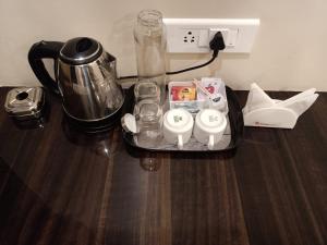 a tray with a tea kettle and cups on a table at Veeras Residency in Puducherry