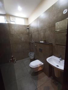 La salle de bains est pourvue de toilettes et d'un lavabo. dans l'établissement Veeras Residency, à Pondichéry