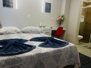 a bedroom with a bed with blue towels on it at CASA HOTEL PIRACICABA in Piracicaba