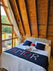 um quarto com uma cama num quarto com tectos em madeira em Sítio Família Cherba - Cabana do Lago em Videira