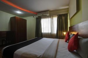 una habitación de hotel con una cama grande con almohadas rojas en OYO Townhouse 803 Jp Residency Near Delhi Airport, en Nueva Delhi