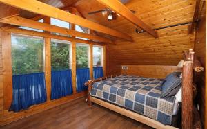 ein Schlafzimmer mit einem Bett in einer Holzhütte in der Unterkunft 4 Cubs Cove in Pigeon Forge