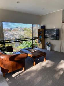 a living room with a couch and a coffee table at Palm Garden Apartment in Auckland