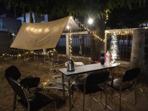 einen Tisch mit Stühlen und ein Zelt mit Beleuchtung in der Unterkunft Punsuk in Khon Kaen