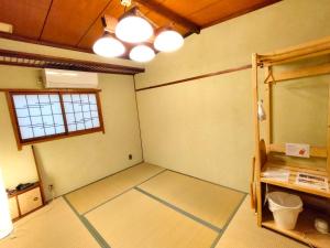 Habitación vacía con ventana y espejo en Hostel Caranashi en Osaka