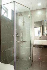 uma casa de banho com uma cabina de duche em vidro e um lavatório. em Ngọc Anh Hotel em Con Dao