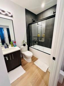 Un baño con inodoro, lavabo y ducha. en B19 Modern Stylish 2bed Basement Suite, en Edmonton