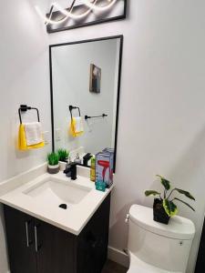a bathroom with a sink and a toilet and a mirror at B19 Modern Stylish 2bed Basement Suite in Edmonton +16 photos