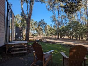 two chairs and a picnic table in a yard at Tiny House 21 at Grampians Edge in Dadswells Bridge