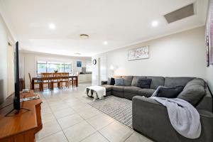 a living room with a couch and a dining room at Mason's Lodge - Family Entertainer, Close to Mall in Dubbo