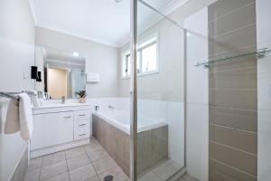 a white bathroom with a shower and a sink at Mason's Lodge - Family Entertainer, Close to Mall in Dubbo +18 photos