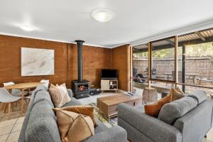 sala de estar con 2 sofás y chimenea en Split Point Cottages, en Aireys Inlet