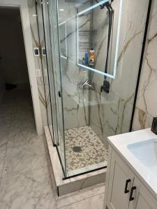 y baño con ducha y puerta de cristal. en Illuminati Guest House en Victoria