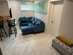 sala de estar con sofá azul y silla en Illuminati Guest House en Victoria