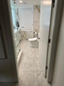 Baño blanco con aseo y lavamanos en Illuminati Guest House en Victoria