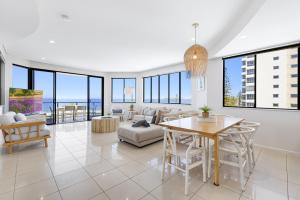 a living room with a table and chairs at Meridian Alex Beach Apartments in Alexandra Headland
