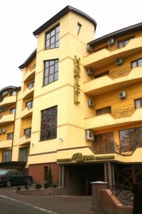 a yellow building with a car parked in front of it at Duet Plus in Uzhhorod