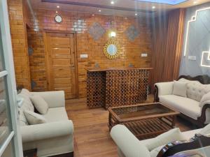 シムラーにあるShimla Abodeのリビングルーム(白いソファ、暖炉付)