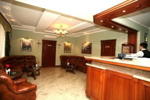 a man standing at a bar in a hotel lobby at Duet Plus in Uzhhorod