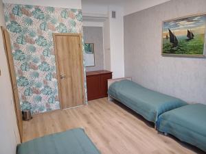 Habitación pequeña con 2 camas y puerta en Green Oaks Private Rooms with Private Shower en Klaipėda