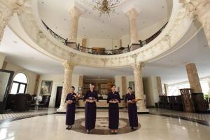 The Grand Palace Hotel Yogyakarta في يوغياكارتا: مجموعة من الناس واقفين في بهو الفندق