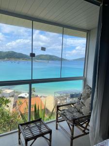 a room with a view of the ocean from a window at Pousada do Mirante do Atalaia in Arraial do Cabo