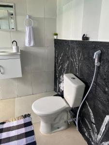 a bathroom with a white toilet with a hose at Pousada do Mirante do Atalaia in Arraial do Cabo