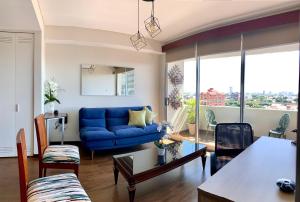 ein Wohnzimmer mit einem blauen Sofa und einem Tisch in der Unterkunft Ciprés Confort in Santa Cruz de la Sierra