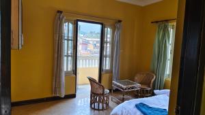 Bodhi Homestay في كاتماندو: غرفة نوم بسرير وكراسي ونافذة