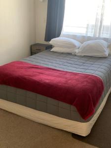 a large bed in a bedroom with a window at Aaron Court Motel in Timaru