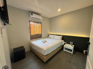 a small bedroom with a bed and a window at De Lux Bangkok Hotel in Ban Khlong Lat Bua Khao