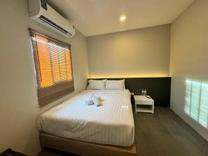 Un dormitorio con una cama y una ventana con una toalla. en De Lux Bangkok Hotel en Ban Khlong Lat Bua Khao
