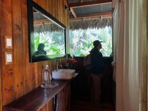 una persona che guarda fuori dalla finestra di un bagno di Hacienda Herrera Tambopata a Puerto Maldonado
