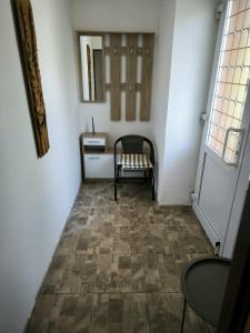 a hallway with a chair and a table and a mirror at Apartmán u potoka in Kestřany
