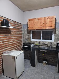 uma cozinha com armários de madeira e um frigorífico branco em El gumer em San Fernando del Valle de Catamarca