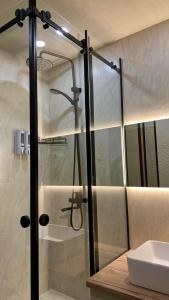 um chuveiro com uma porta de vidro na casa de banho em Алматы Транзит №1 em Turksib