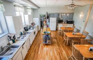 uma cozinha com pisos em madeira e bancadas e mesas brancas em Harbor Landing Resort em Vineyard Haven
