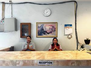 two women standing in a room with their hands up at SUNRISE HOTEL LABUAN BAJO in Labuan Bajo