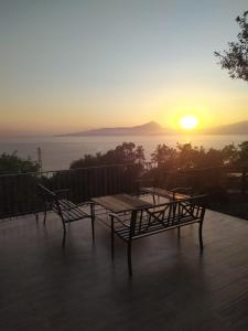 a table and chairs on a deck with the sunset at Sanacore - Maratea - Cersuta in Maratea