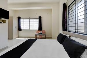 1 dormitorio con cama grande y ventana grande en OYO Power Spirits Boarding and Lodging, en Bangalore