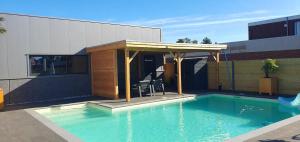a swimming pool with a pavilion next to a building at Klein duimpje in Echt