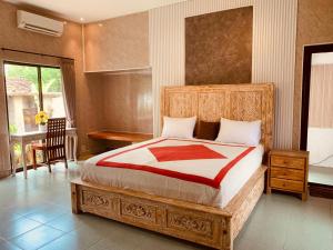 ein Schlafzimmer mit einem großen Bett mit einem Holzrahmen in der Unterkunft Villa Mahesa in Ubud