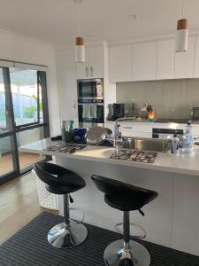 旺阿雷Town View Homestay的厨房配有厨房柜台上的2把吧台凳