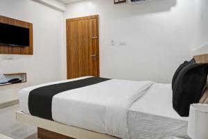 - une chambre avec un lit et une porte en bois dans l'établissement Collection O Hotel Stay Prime Baner, à Pune